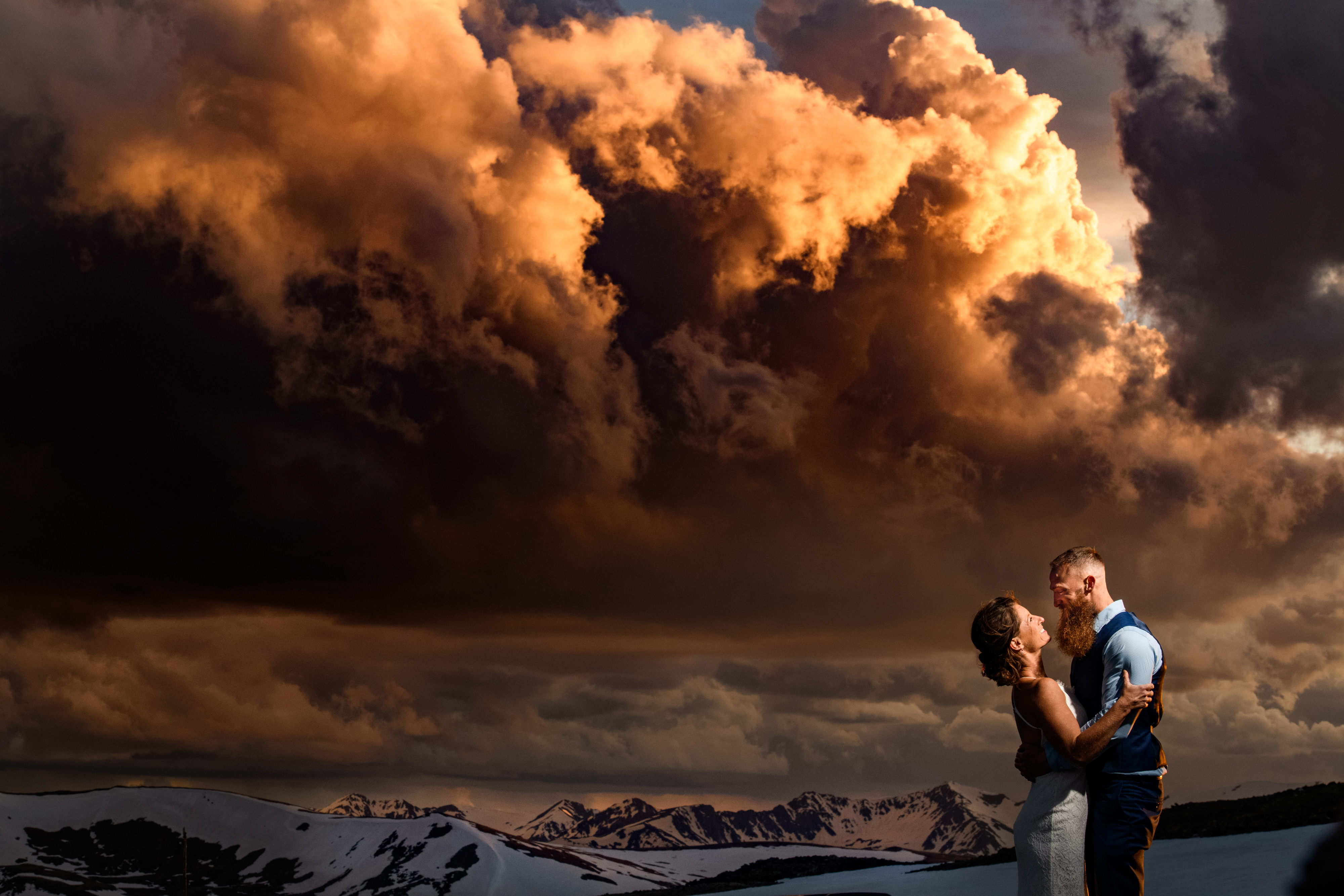 A wedding couple under a dramatic sky in the mountains of Colorado