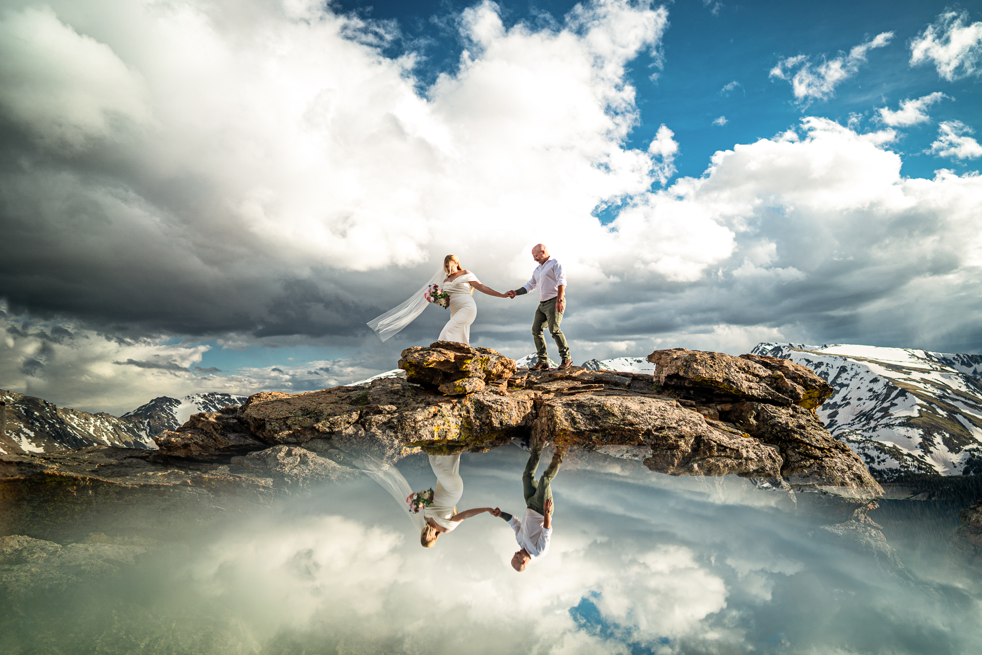 Wedding day couple walking at the top of the mountains in Rocky Mountain National Park
