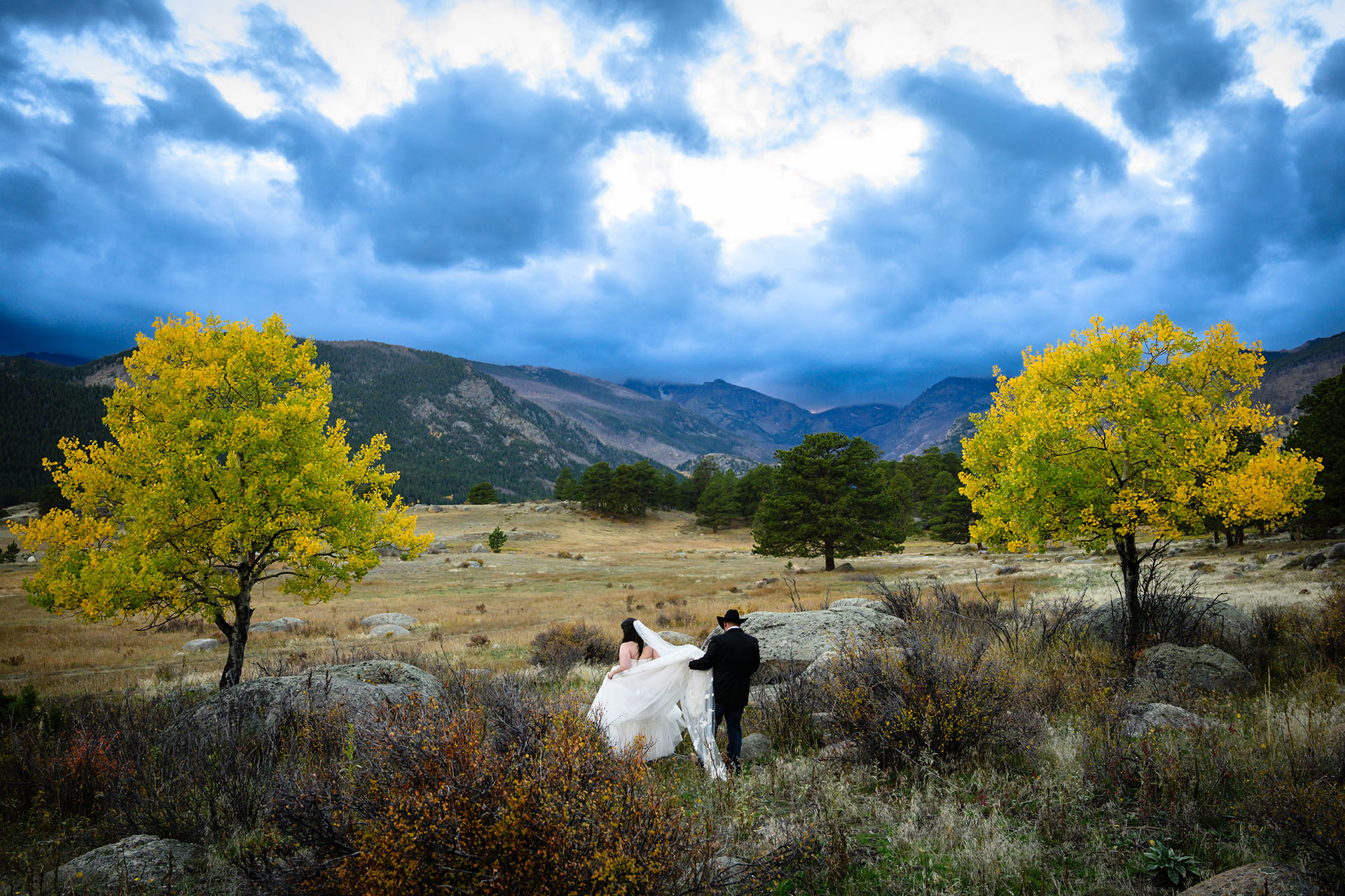 Bride and groom walk into Rocky Mountain National Park on a beautiful Fall day