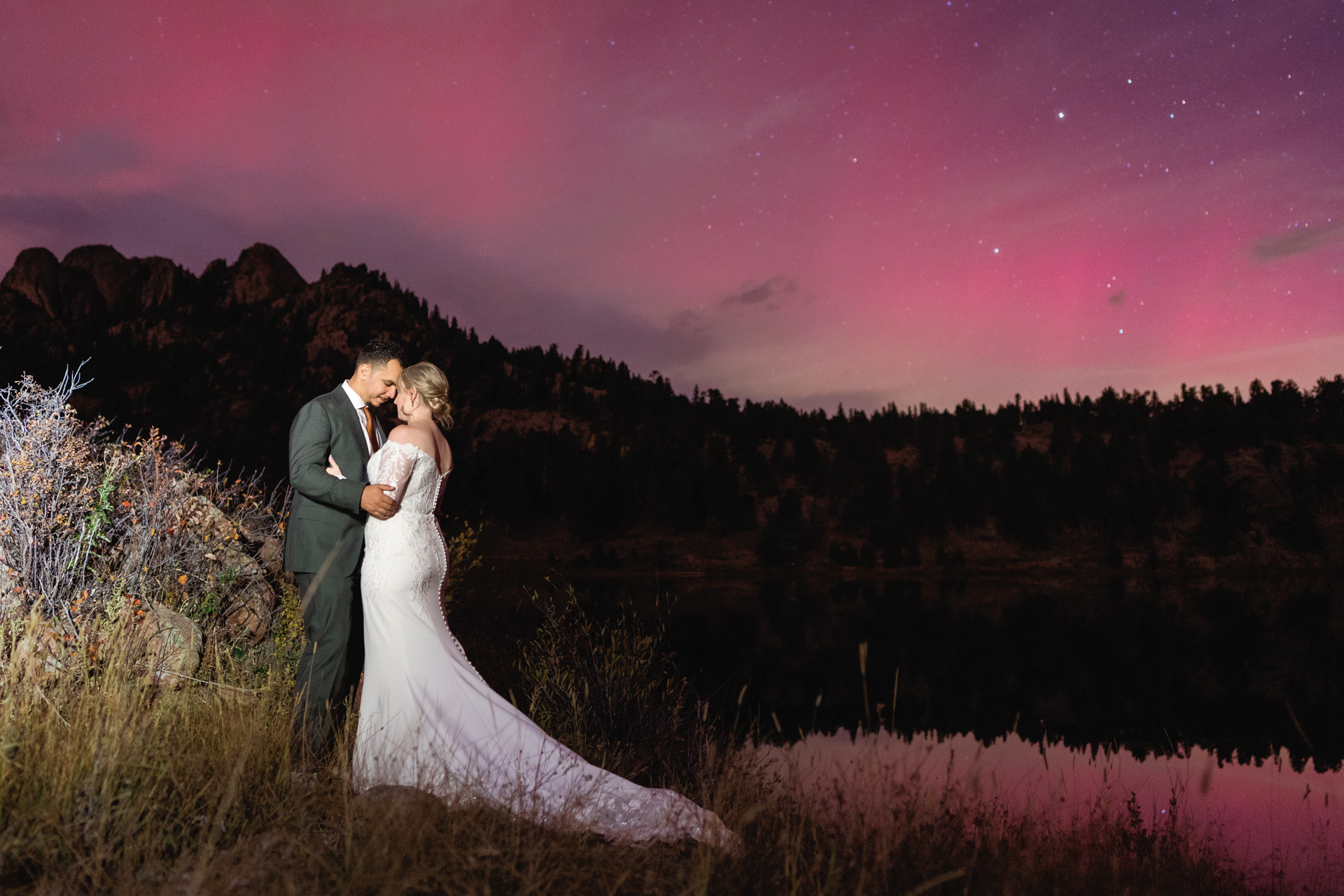 A wedding couple under an aurora in Rocky Mountain National Park, Colorado