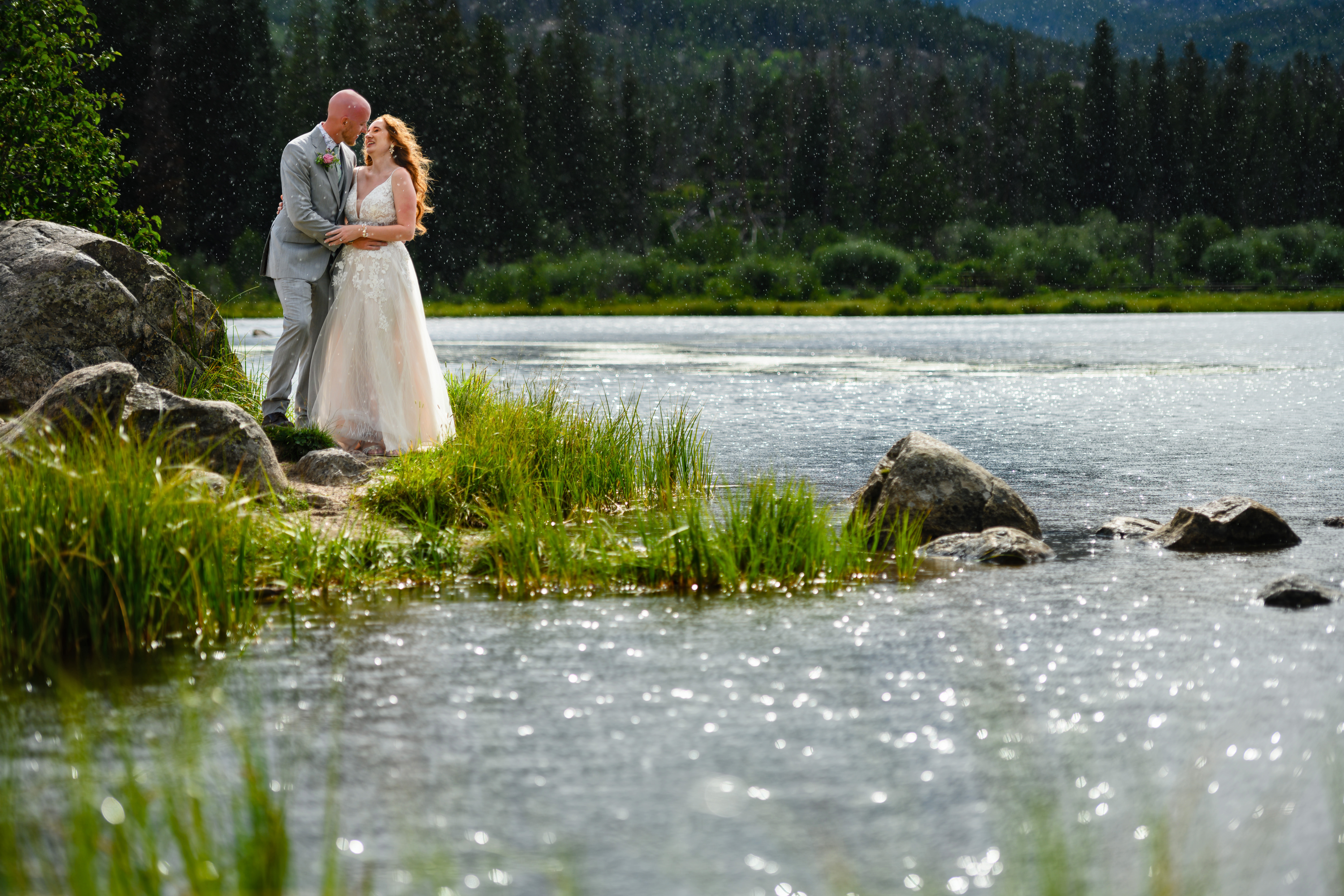 Wedding couple holding each other by a lake in Rocky Mountain National Park, Colorado
