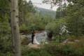 A couple hugging on their wedding day looking down the river at Wild Basin Lodge just outside of Estes Park, Colorado