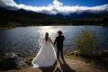 Wedding couple holding hands by a lake in Rocky Mountain National Park, Colorado